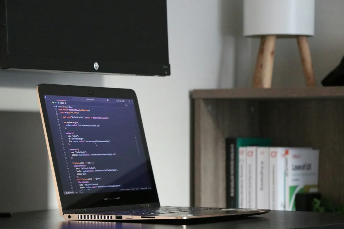 A laptop displaying code in a home workspace