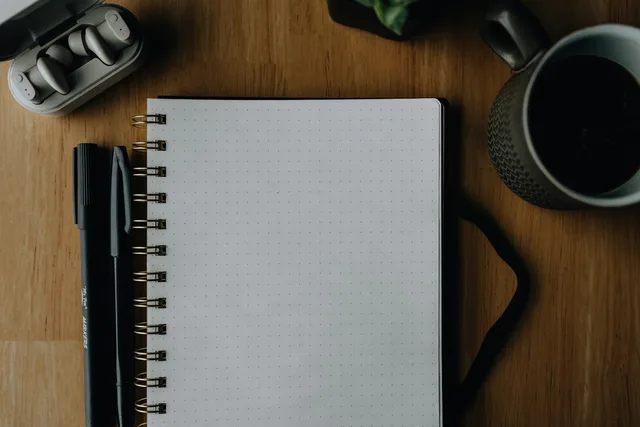 A notebook and pen on a desk, illustrating a space for letters