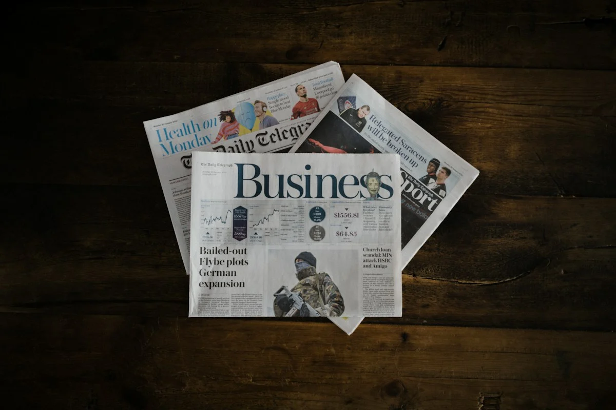 A stack of newspapers on a wooden table, illustrating media literacy